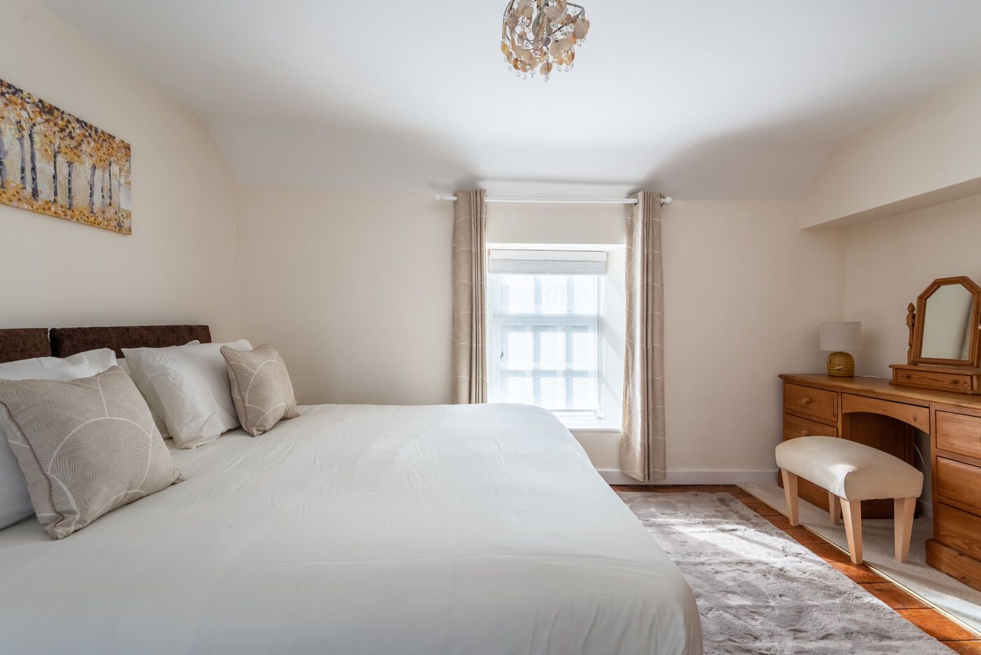 Bedroom two, a light room with a super-king bed and dressing table