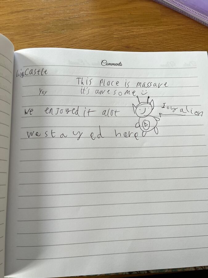 A child's guest book page reading 'This place is massive, it's awesome' with a drawing